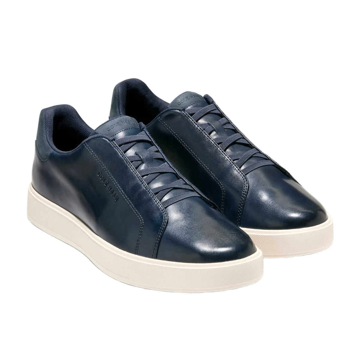 Pair of navy blue sneakers with white soles on a light gray background